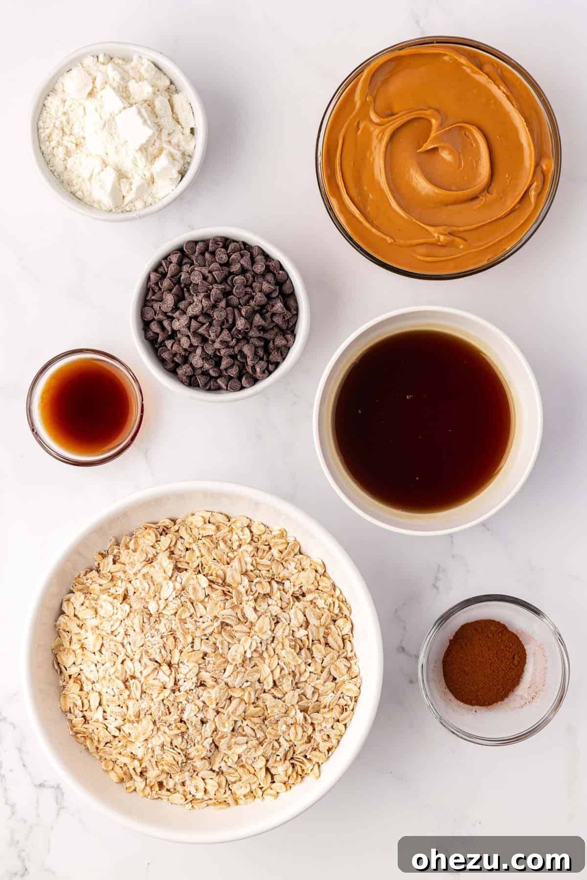All seven ingredients for oatmeal cookie energy balls laid out on a kitchen counter, ready for mixing.