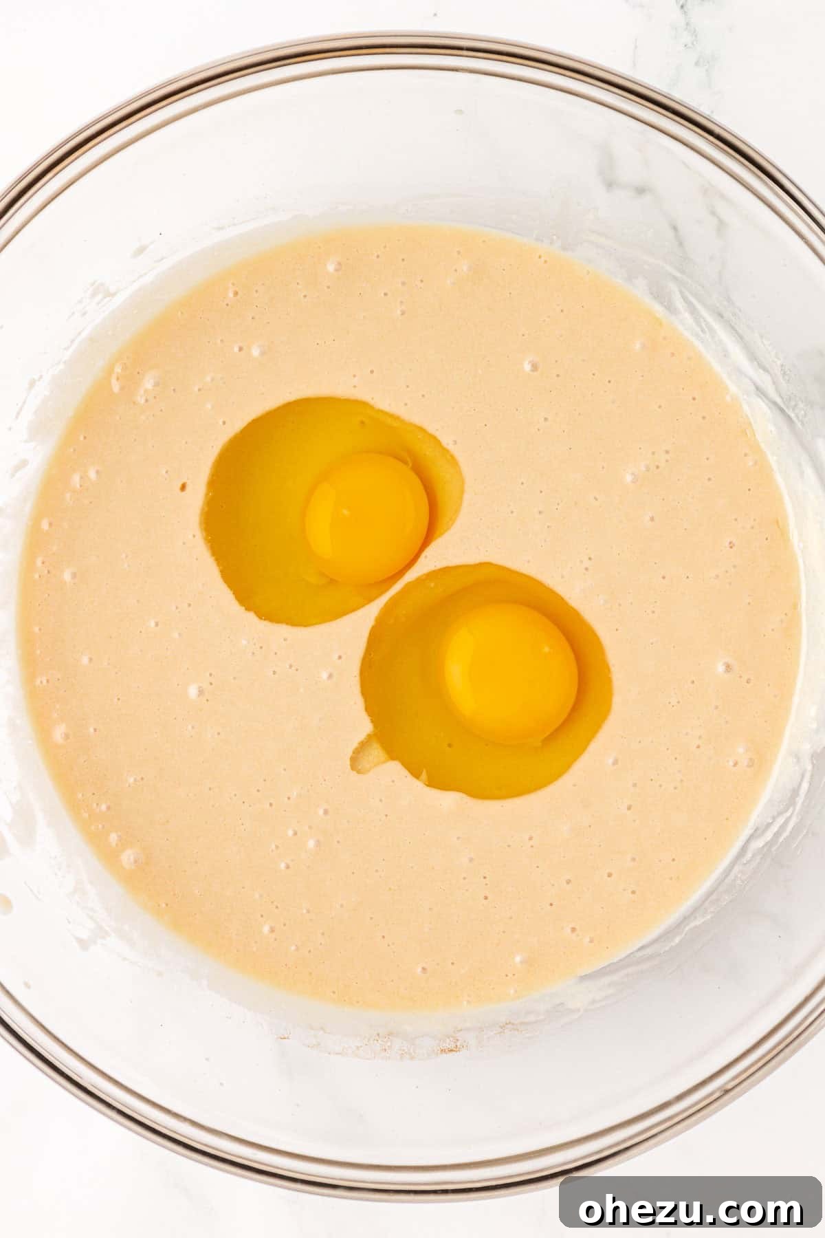 Tangy Greek Yogurt Treat Cake 9 Adding eggs to the wet ingredients for the Greek yogurt snack cake batter