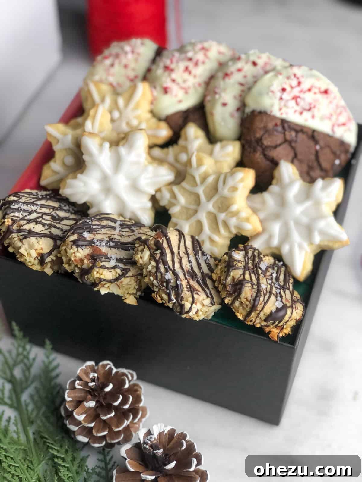 A festive holiday cookie box featuring a variety of flavors, including chocolate peppermint cookies, beautifully arranged for gifting.