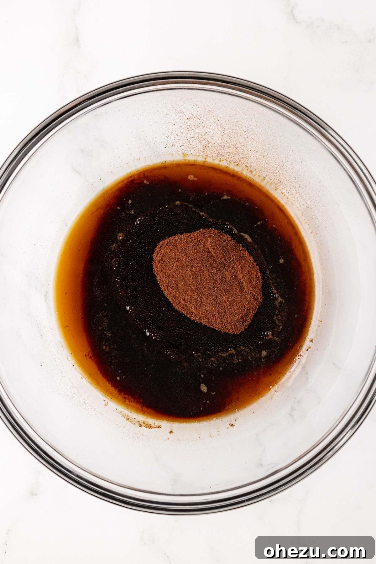 Maple syrup and espresso powder in a mixing bowl before stirring.