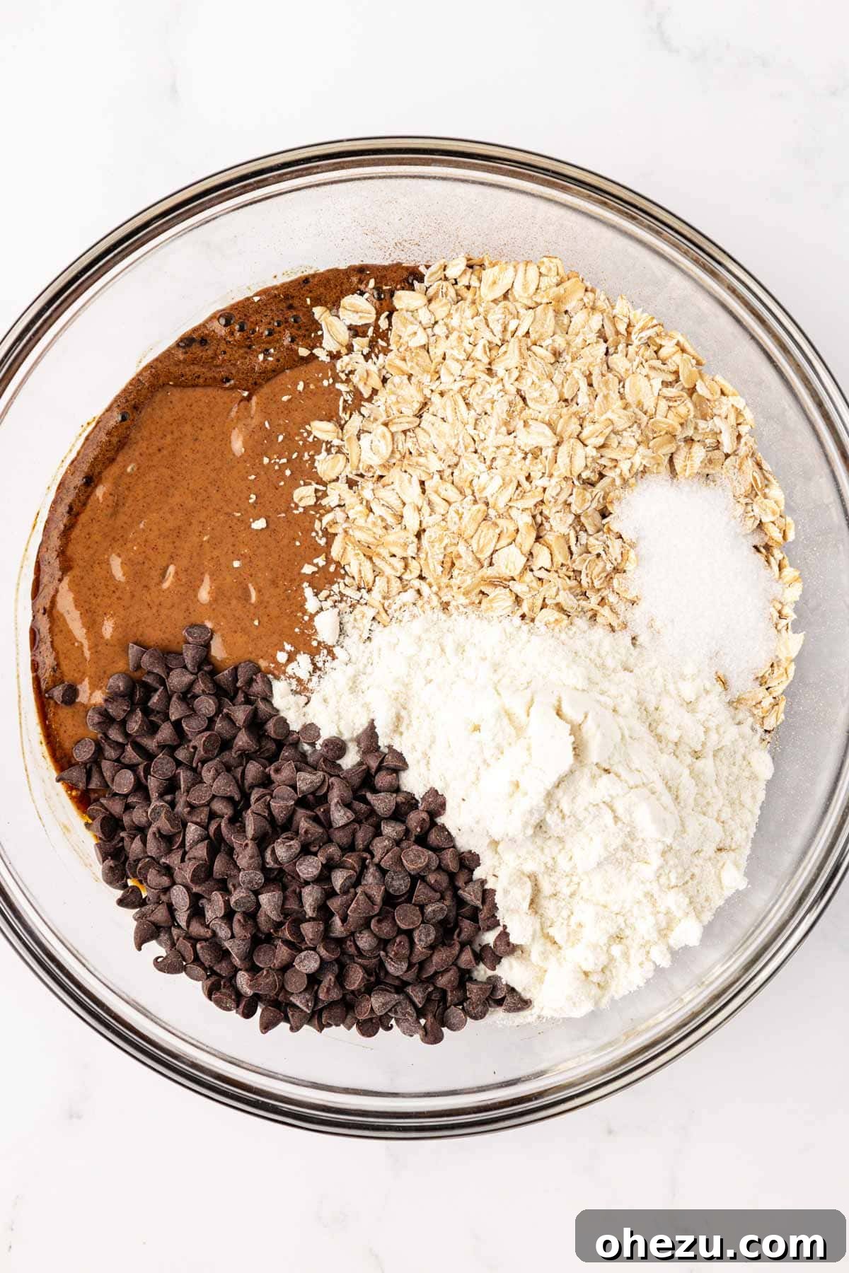 All dry ingredients for espresso energy bites added to the mixing bowl with wet ingredients.