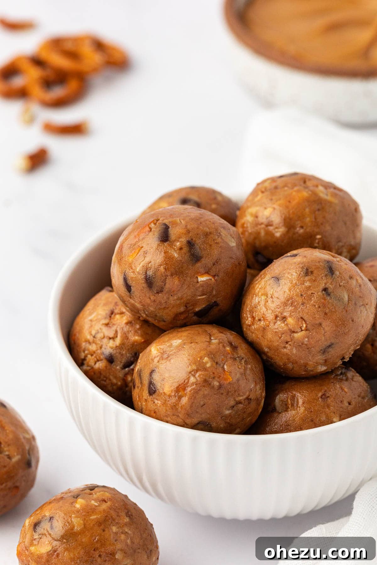 Delicious and healthy peanut butter pretzel energy bites stacked in a pyramid on a white plate