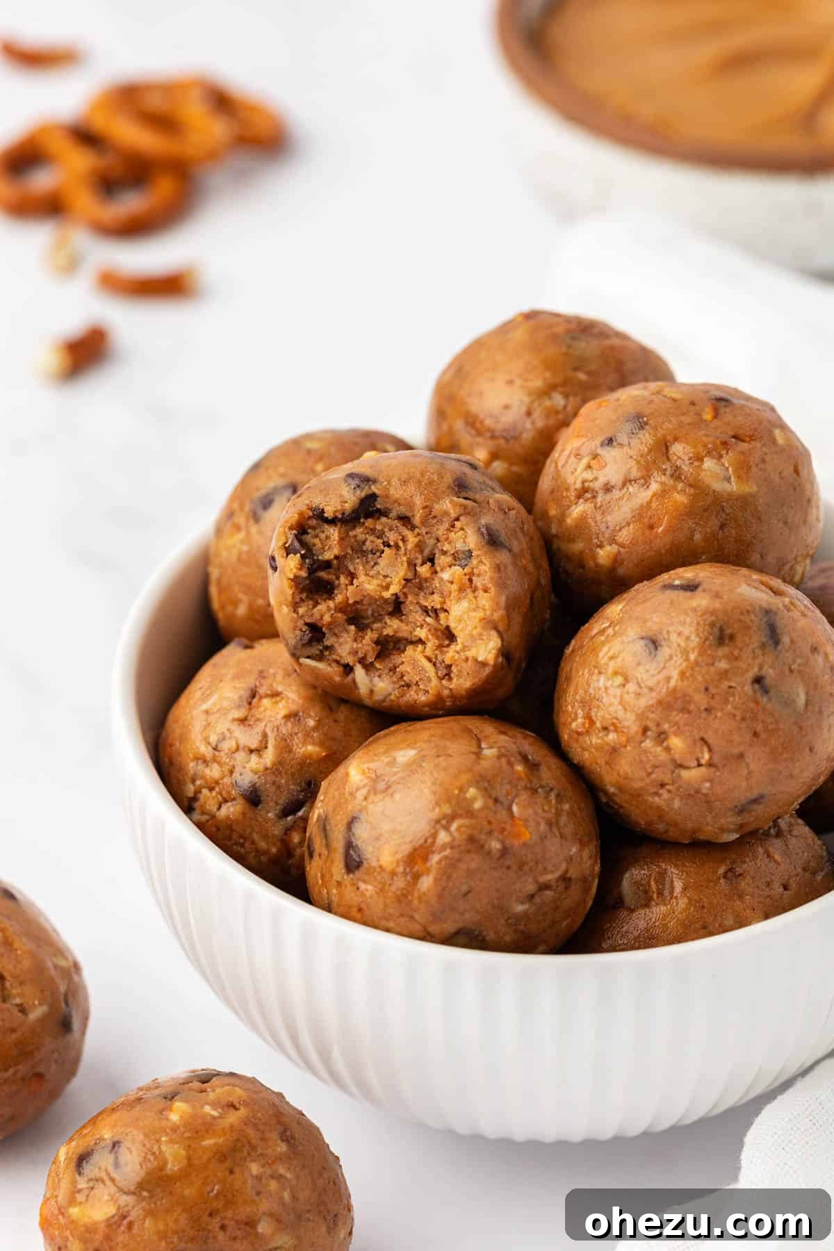 Four peanut butter pretzel energy bites arranged neatly on a white background, highlighting their texture