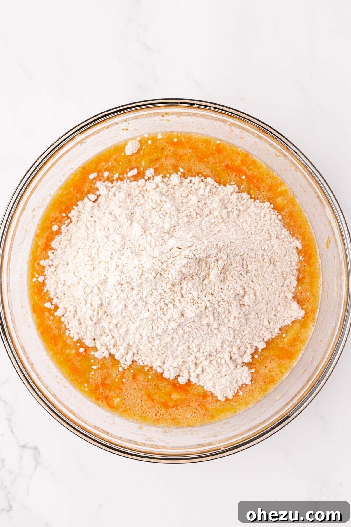 Poppable Perfection Muffins 11 The dry ingredients being gently folded into the wet ingredients in a large mixing bowl.