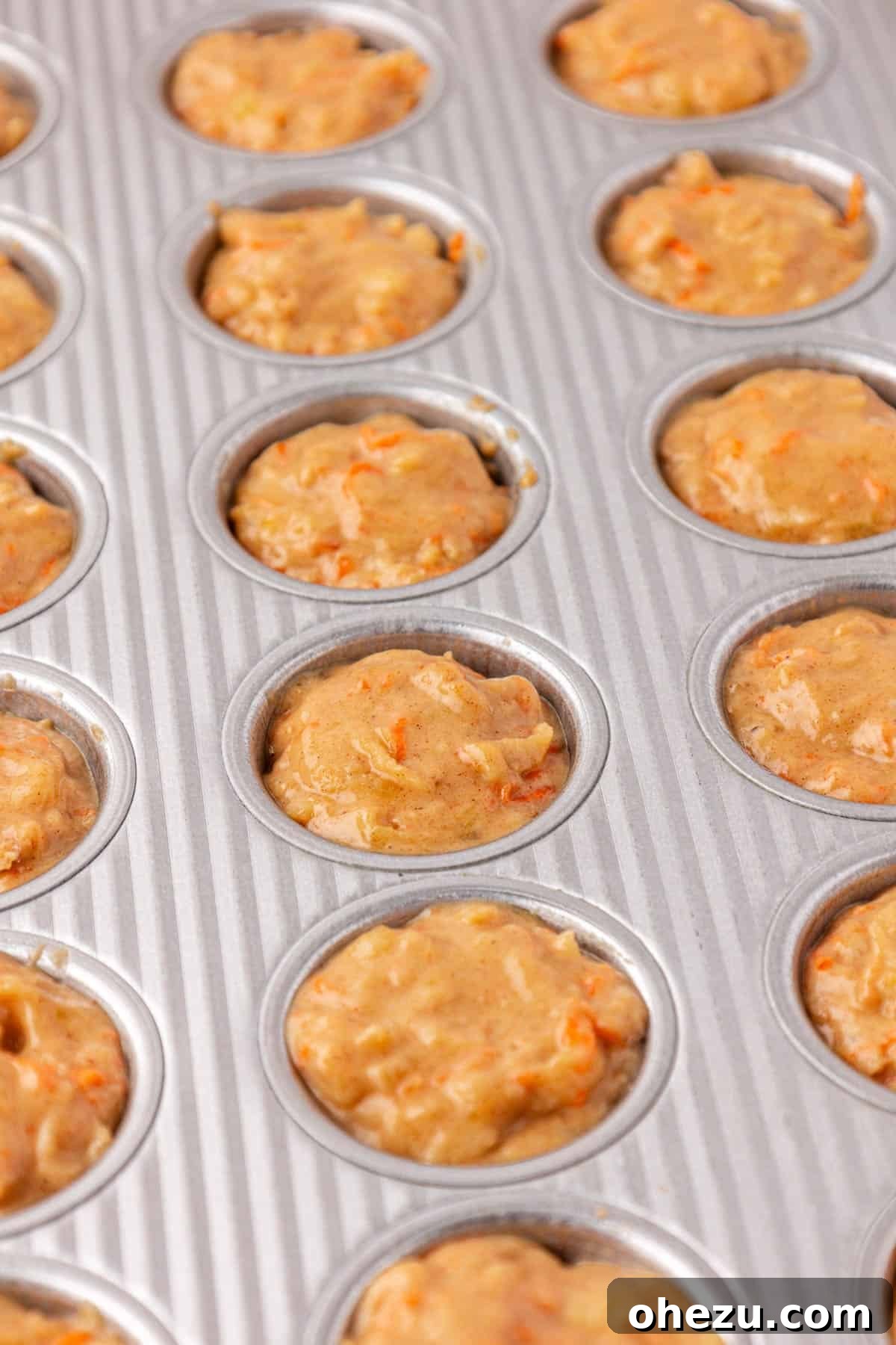 Poppable Perfection Muffins 14 Close-up of the mini muffin tin with each cup filled evenly with ABC muffin batter, ready for baking.