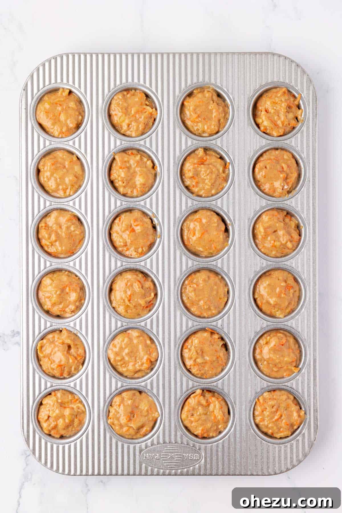Poppable Perfection Muffins 15 ABC mini muffin batter baking in a muffin tin, rising and turning golden in the oven.