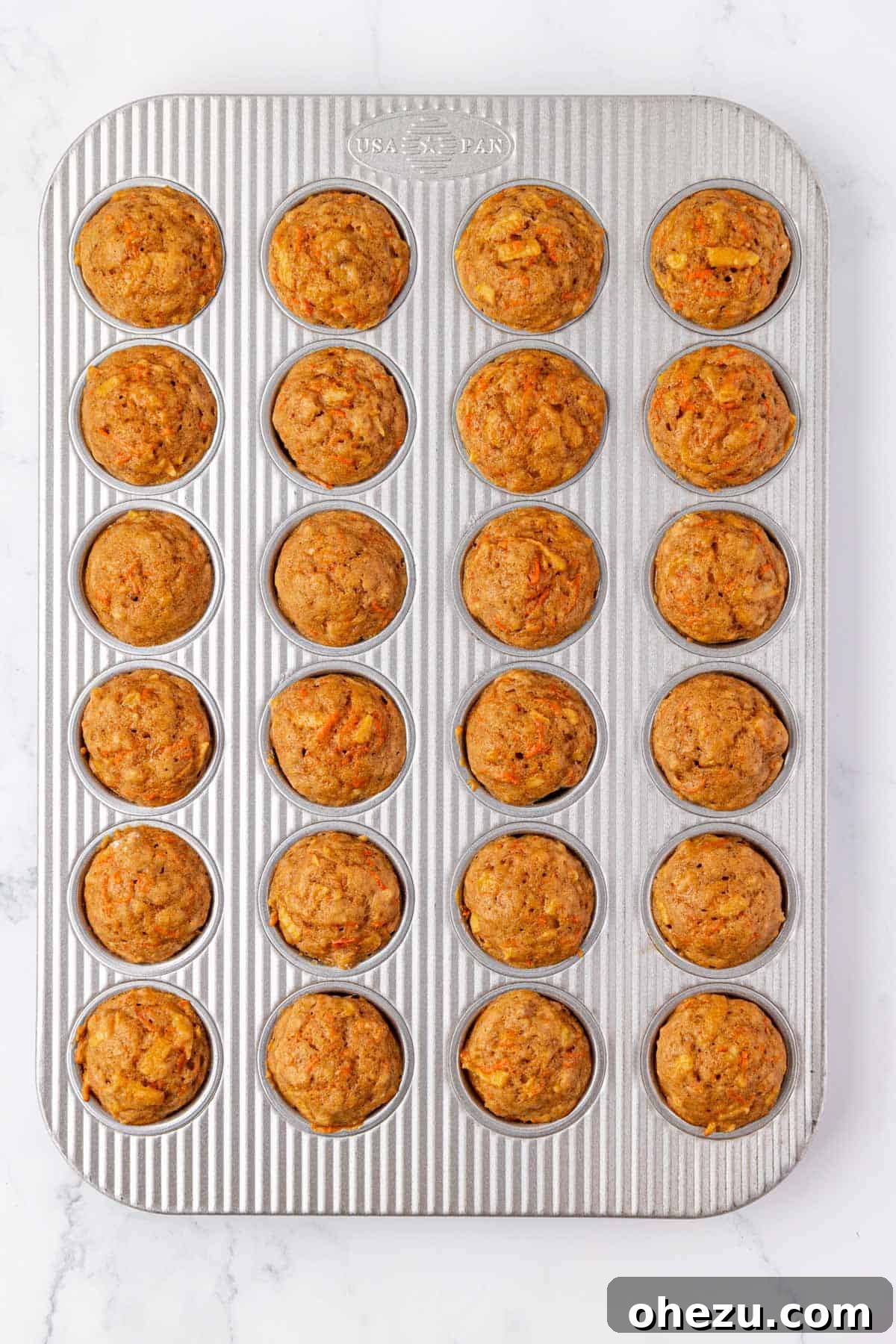 Poppable Perfection Muffins 16 Freshly baked ABC mini muffins, golden brown and puffed up, straight out of the oven in their tin.