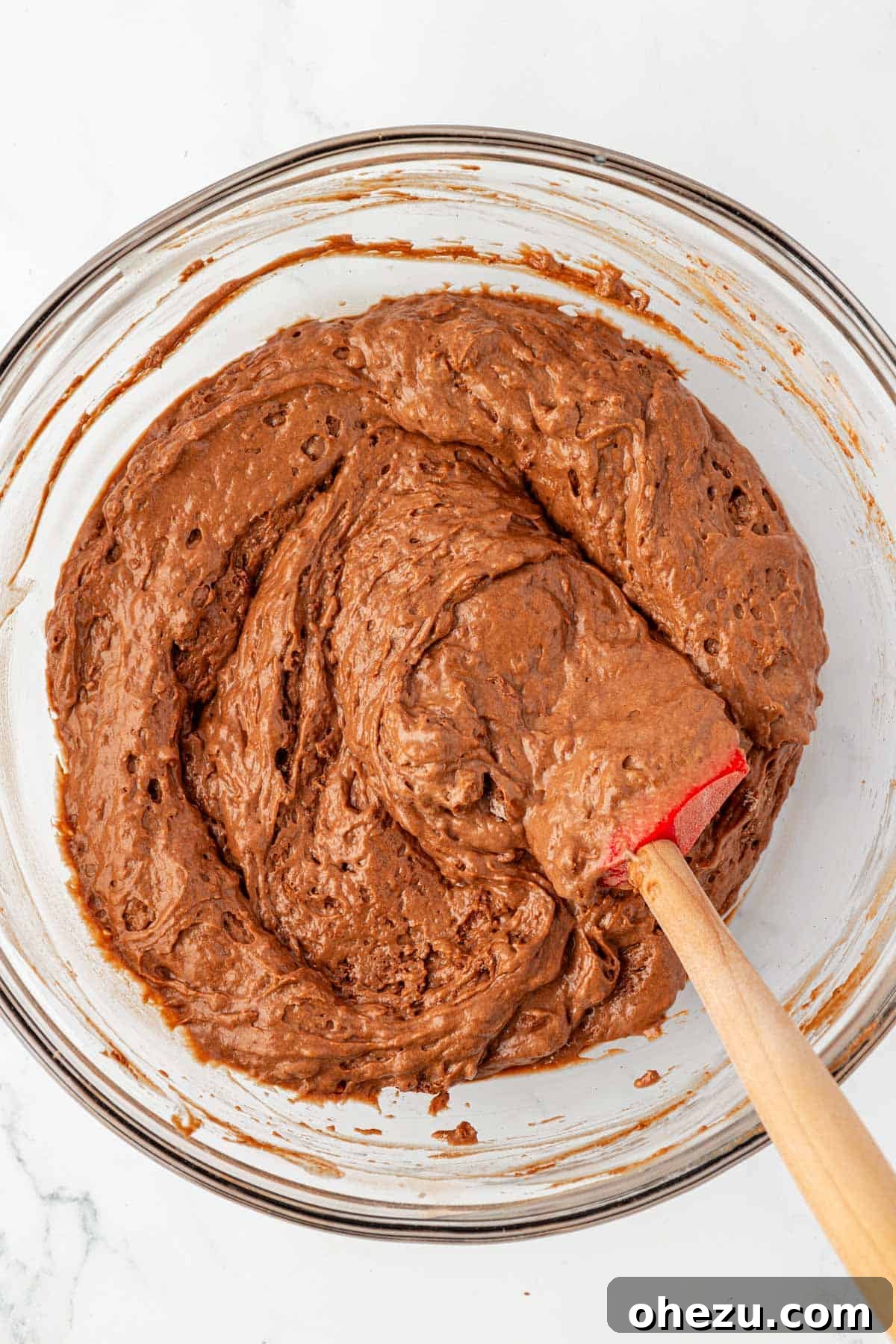 Gently mixing dry and wet ingredients for chocolate snack cake batter