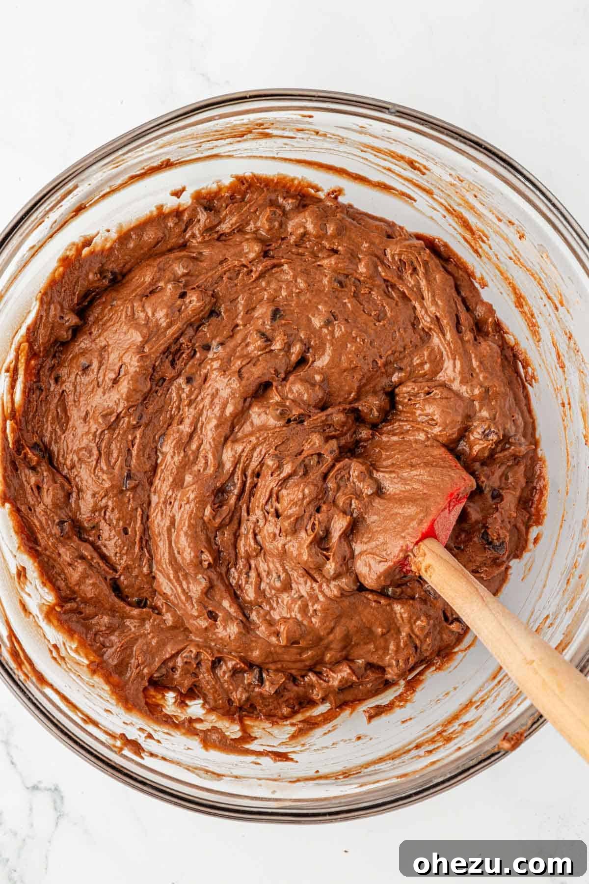 Chocolate snack cake batter with mini chocolate chips gently mixed in