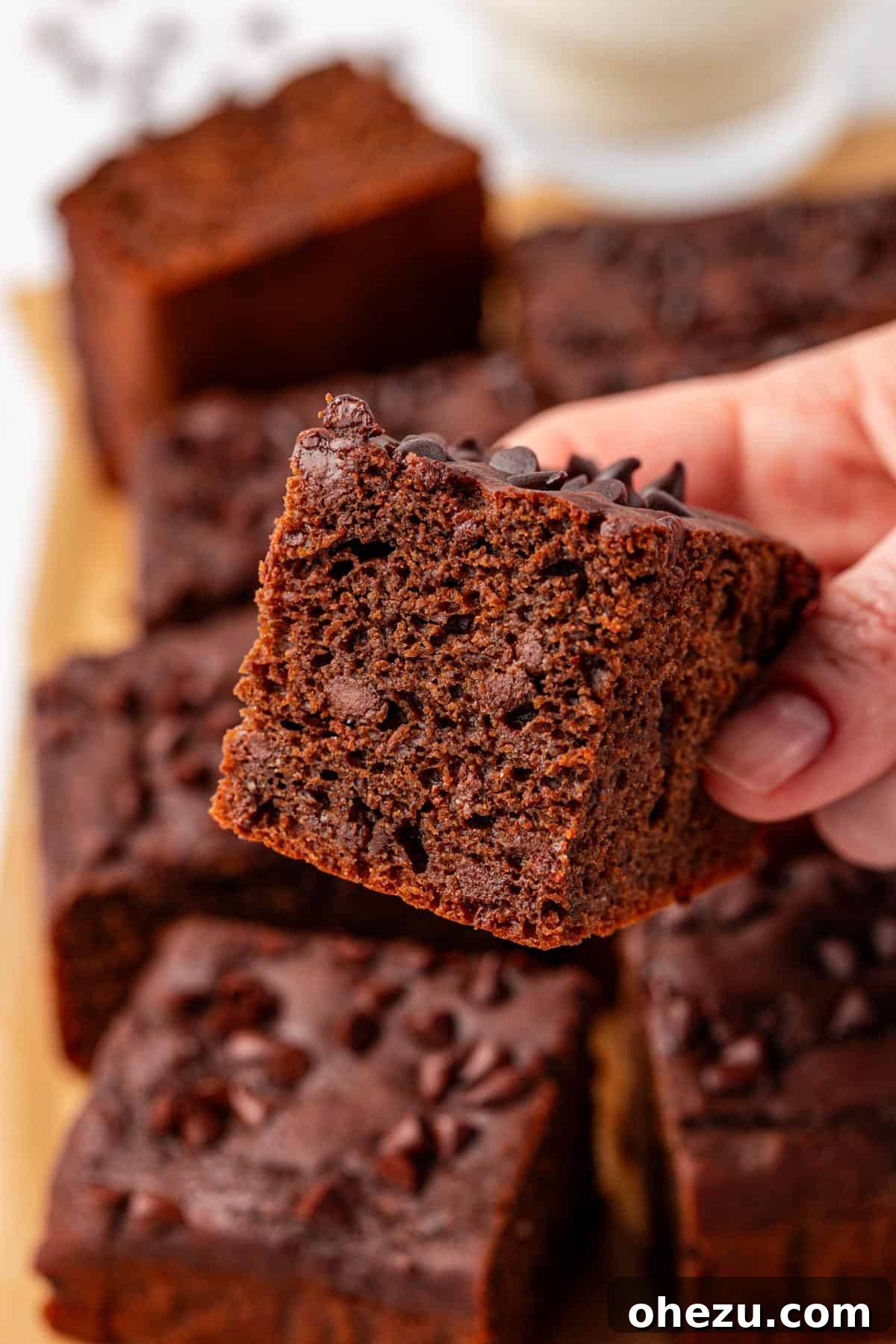 A stack of chocolate snack cake squares on a white plate