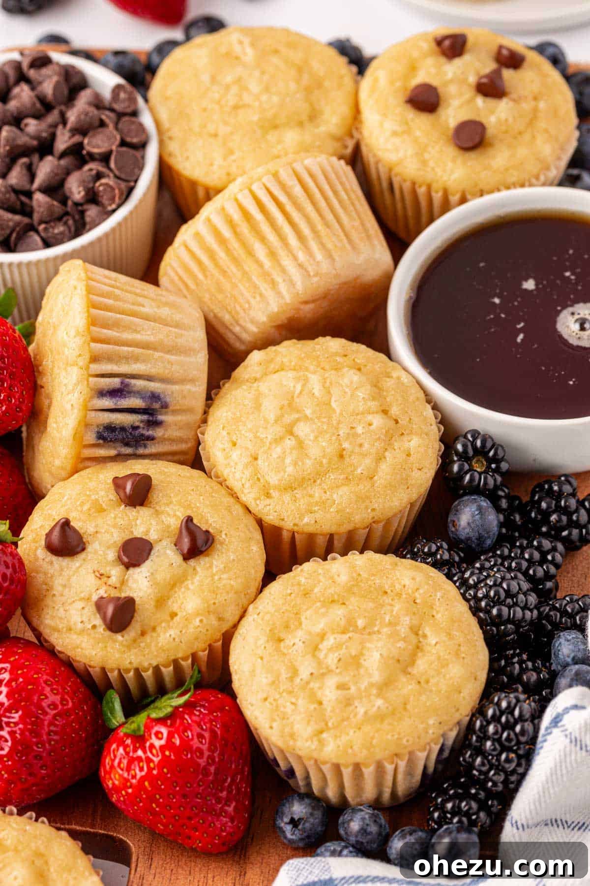 A beautiful arrangement of pancake muffins, some topped with berries, on a serving platter, perfect for a brunch spread.