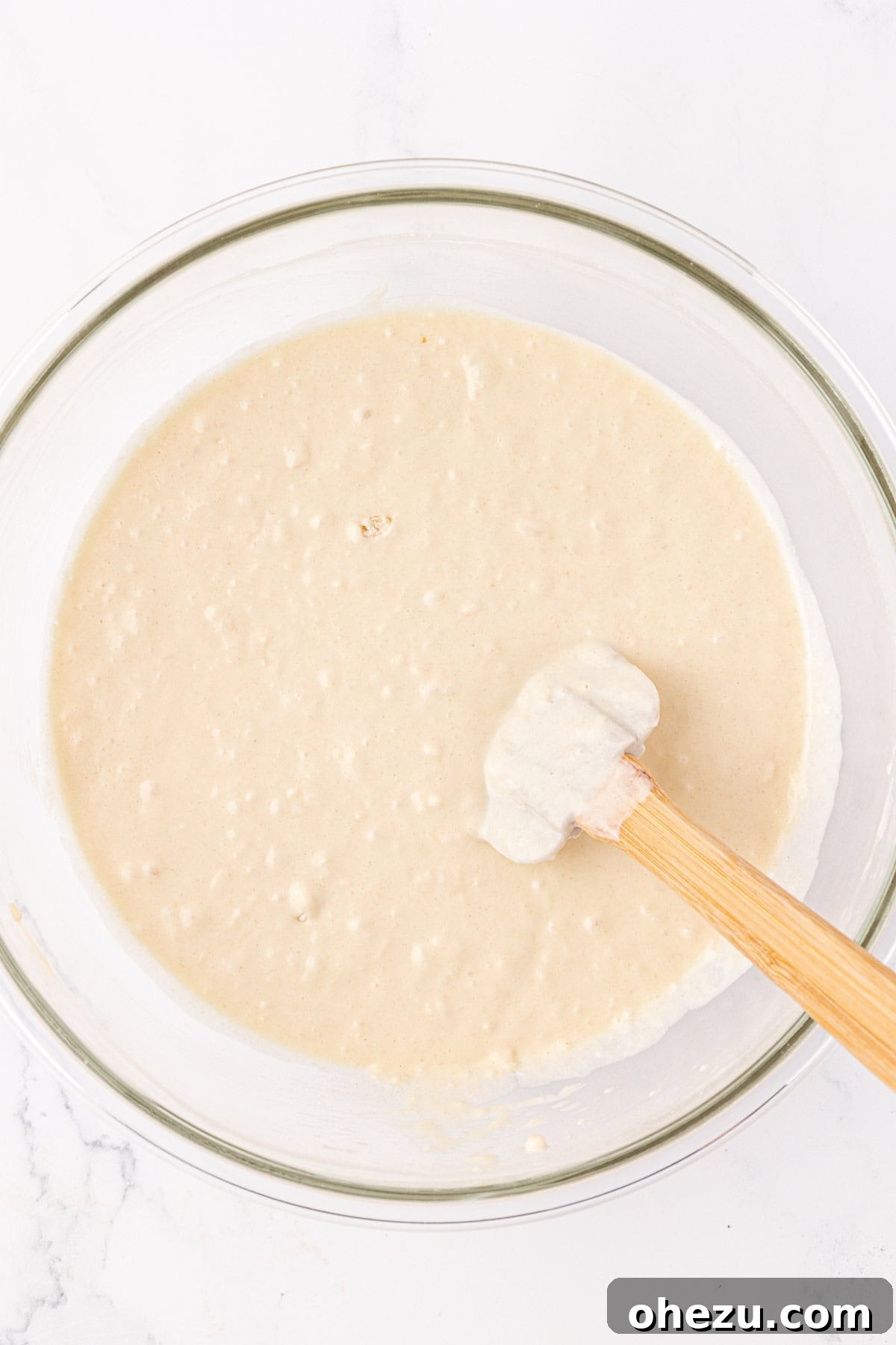 Pancake muffin batter in a bowl after being mixed, showing a slightly lumpy texture.