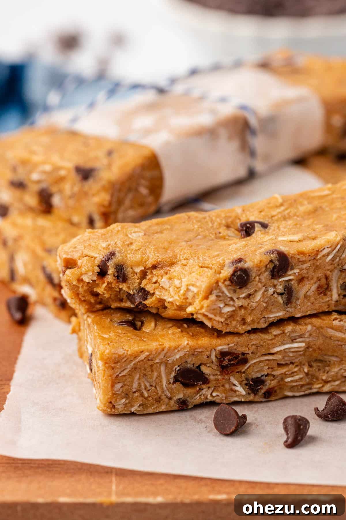 A single perfectly cut protein granola bar, standing upright, with its rich texture and chocolate chips clearly visible.