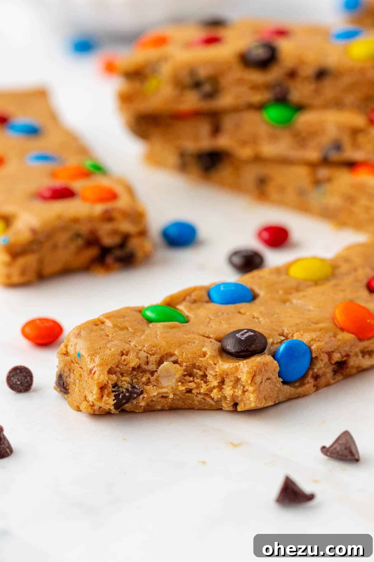 Close up of a single monster cookie protein bar on a wooden surface