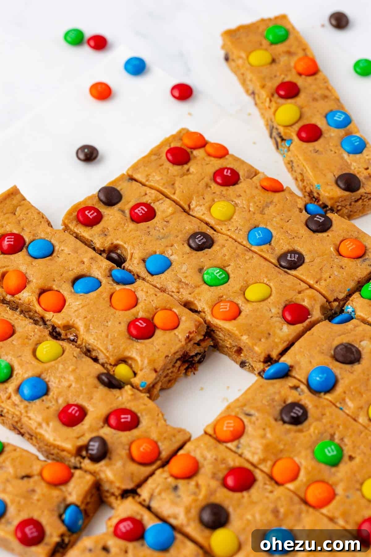 A close-up of a Monster Cookie Protein Bar showing its texture and M&M's