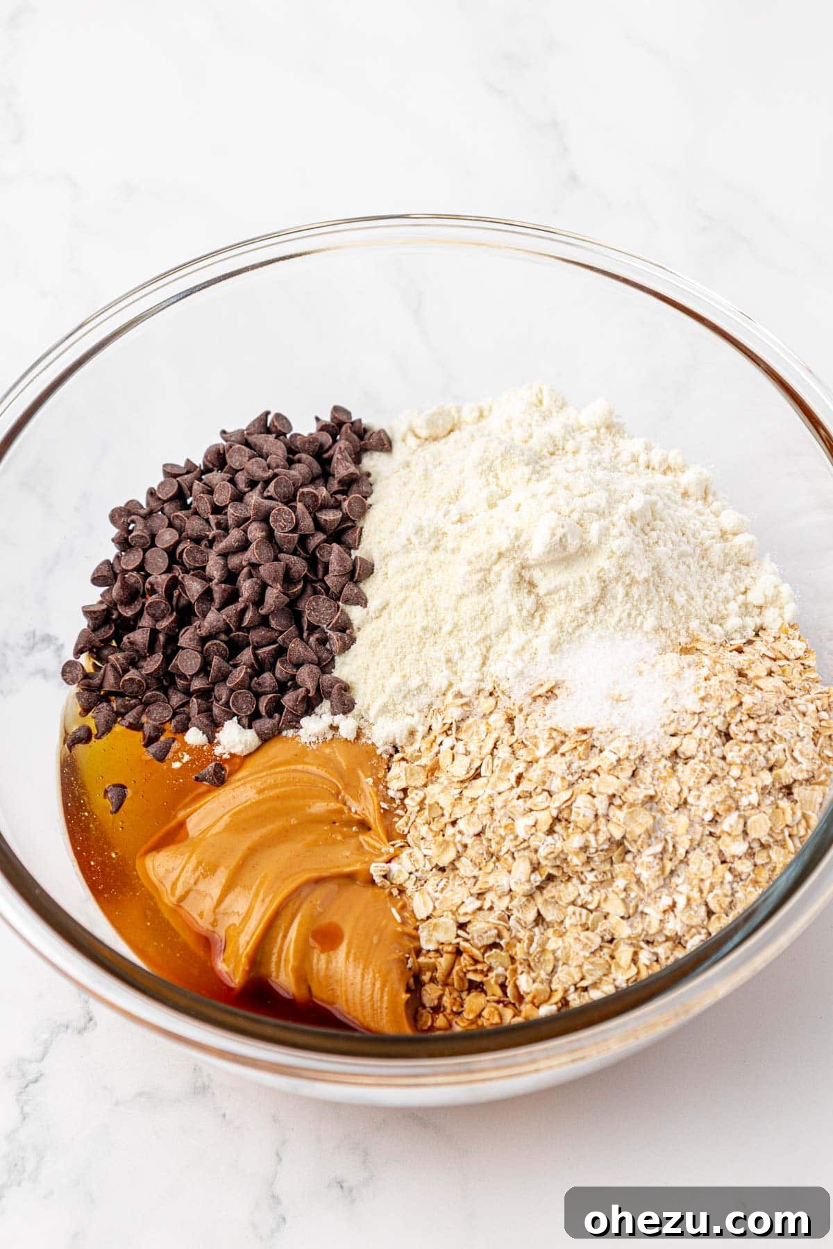 Ingredients for protein bar batter in a mixing bowl before mixing