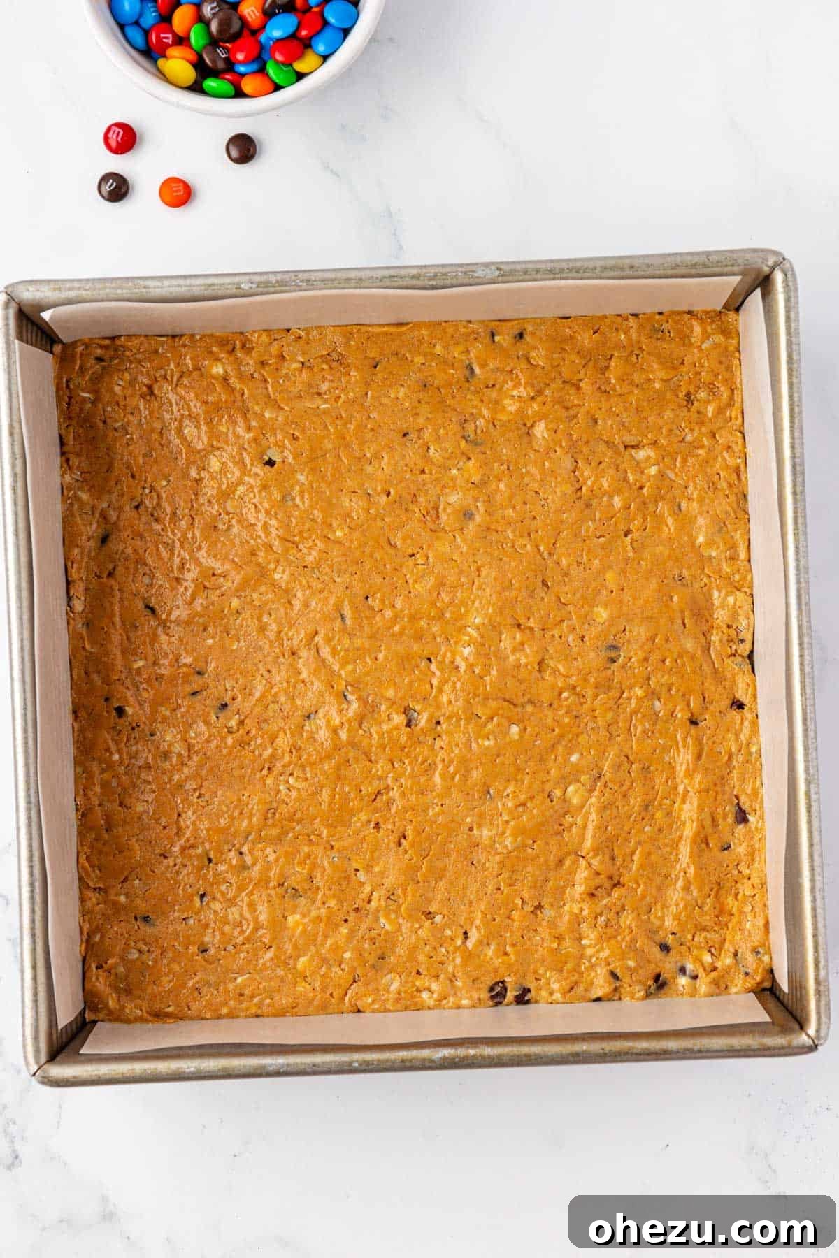 Smooth protein bar batter pressed into a pan before chilling