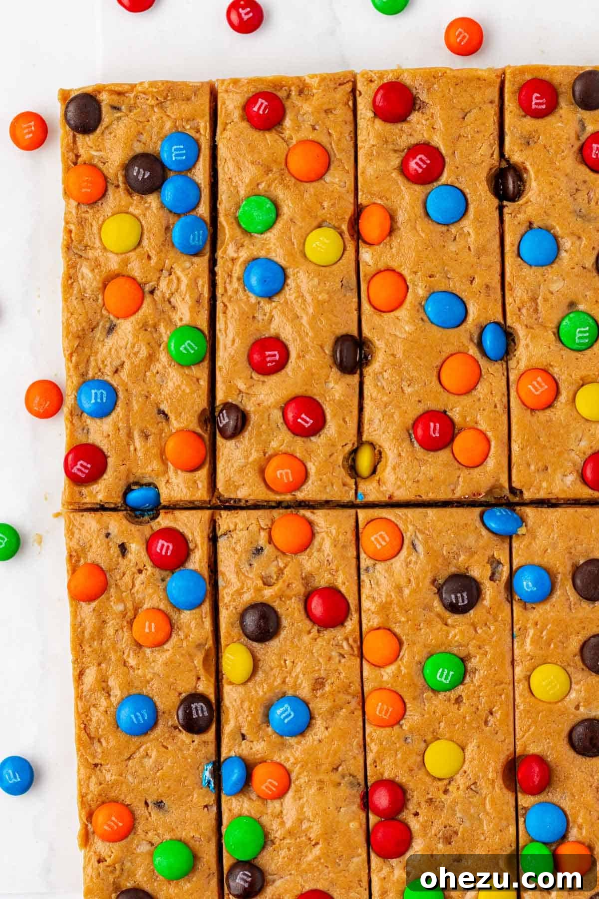 Freshly cut monster cookie protein bars laid out on parchment paper