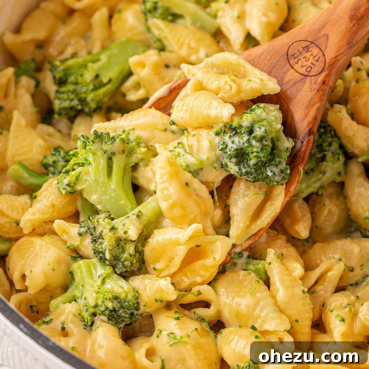 scooping broccoli mac and cheese from the pan