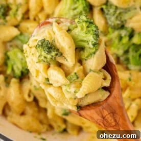 scooping broccoli mac and cheese from the pan