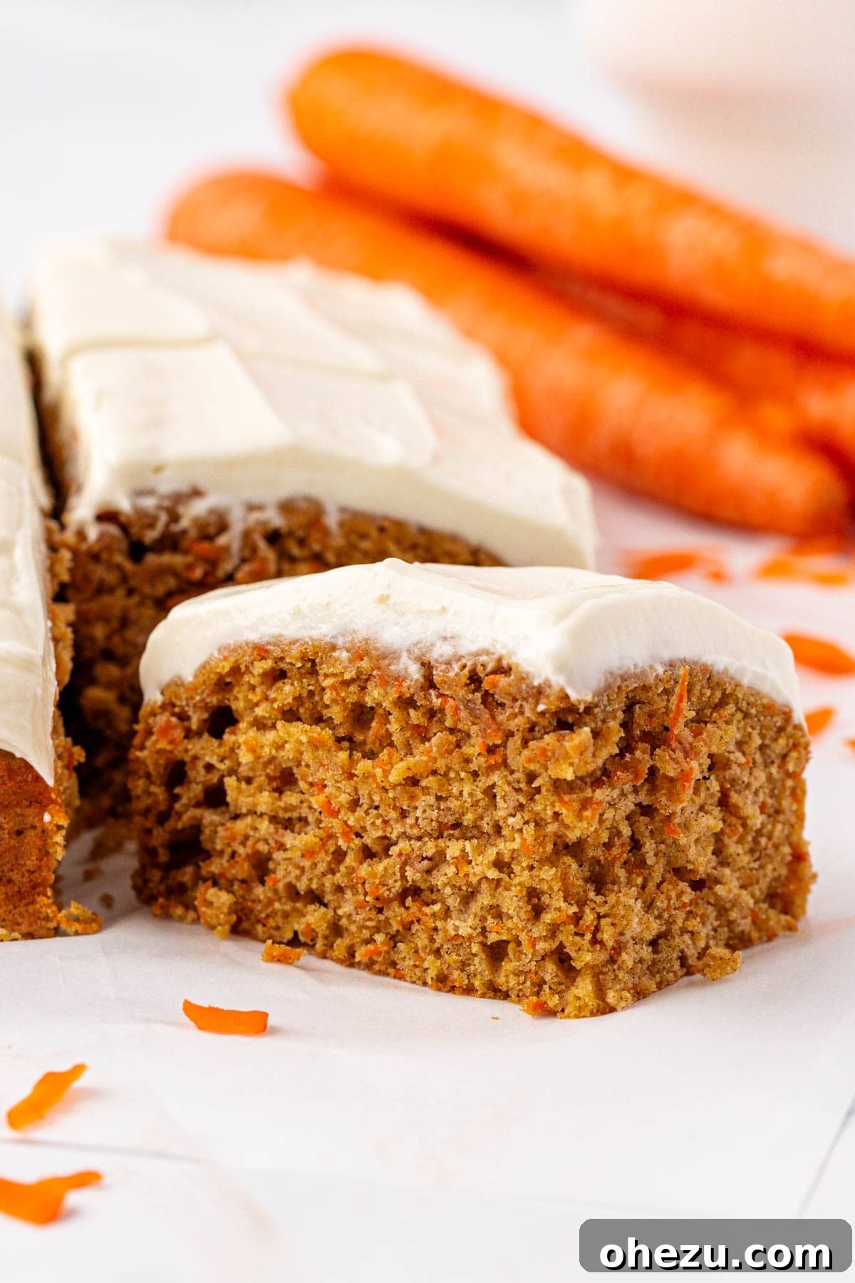 Delicious and healthy carrot cake snack bars topped with creamy white frosting, sliced and ready to serve.