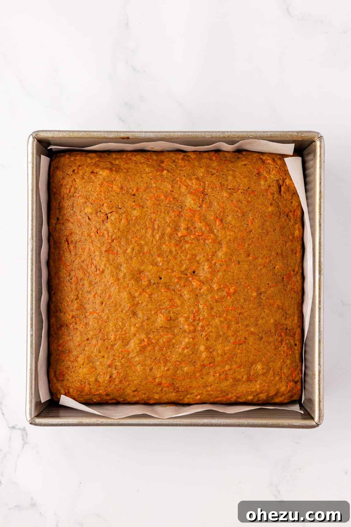 Freshly baked carrot cake bars in the pan, golden brown and fluffy.