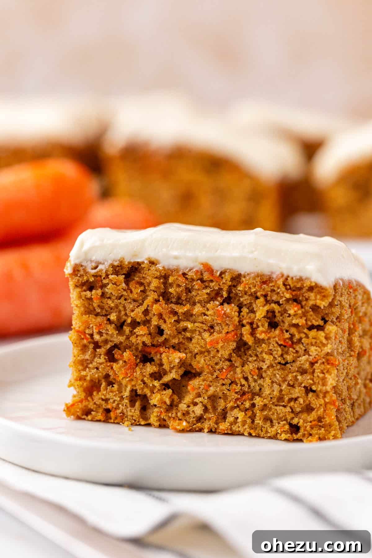 Close-up of a carrot cake snack bar with a bite taken out, revealing the moist interior.