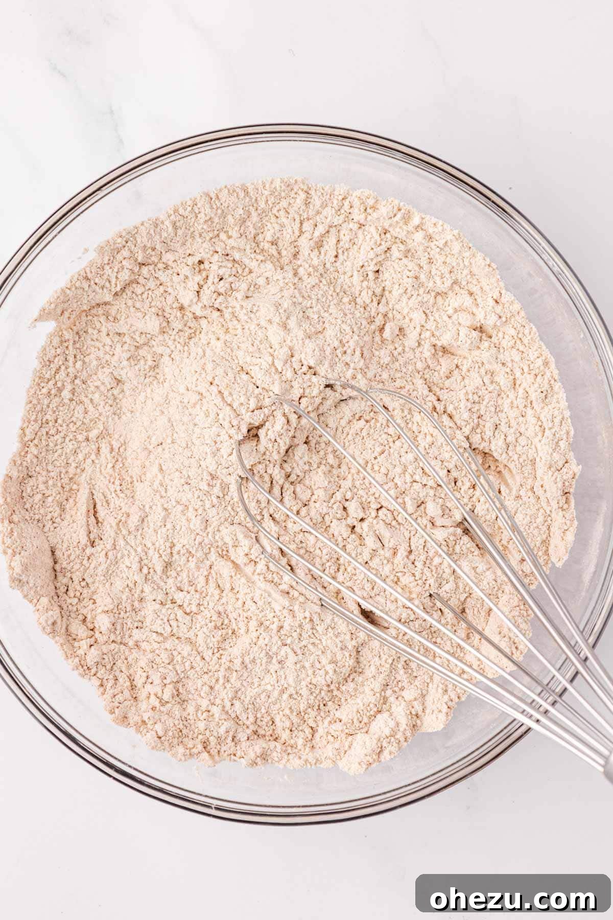 Dry ingredients whisked together smoothly in a mixing bowl.