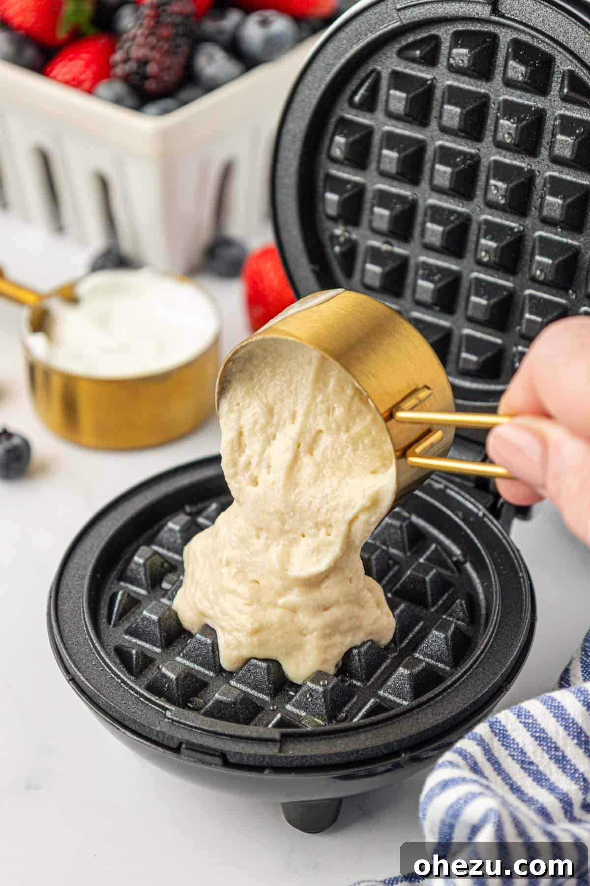 Protein-Packed Greek Yogurt Waffles 12 Pouring Greek yogurt waffle batter into a heated mini waffle maker