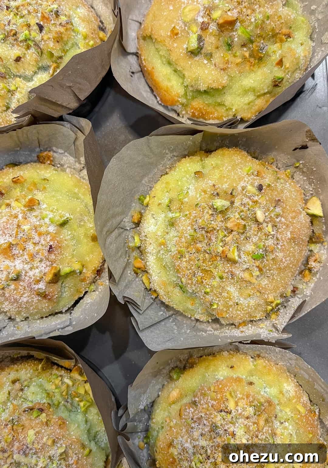 Freshly baked bakery-style pistachio muffins cooling on a wire rack