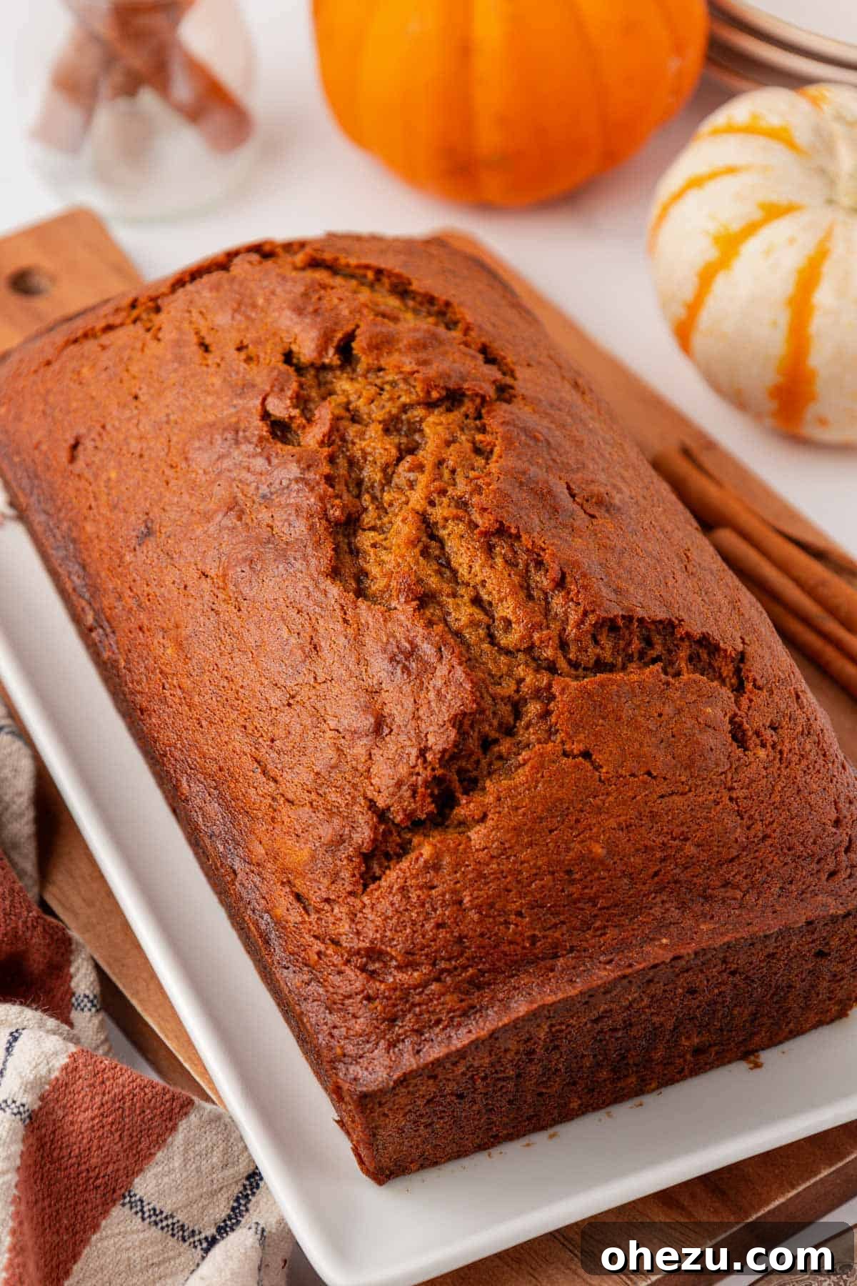 golden brown loaf of moist pumpkin bread cooling on a rack