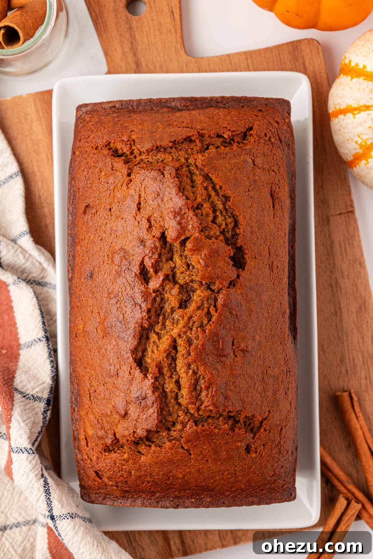 a perfectly baked golden brown pumpkin bread in a loaf pan, fresh out of the oven