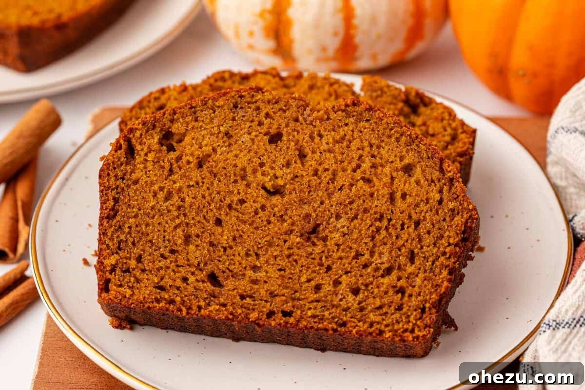a close-up of a perfectly sliced piece of moist pumpkin bread