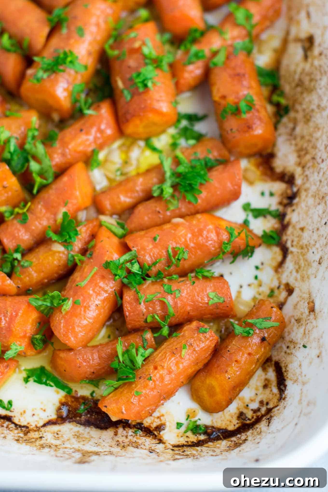 A close-up of vibrant garlic butter roasted carrots garnished with fresh parsley, ready to be served. A delicious, easy, and vegan-friendly side dish perfect for any occasion.