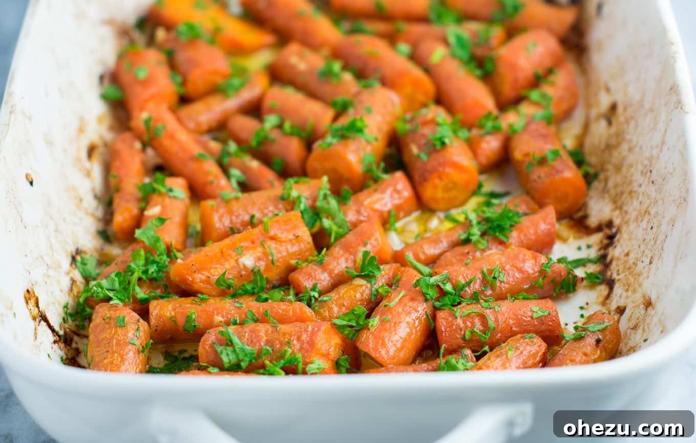 A vibrant medley of garlic butter roasted carrots adorned with fresh green parsley, highlighting their visual appeal and delicious simplicity.
