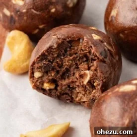 Decadent chocolate cashew energy bites, possibly with a dusting of cocoa or visible cashew pieces
