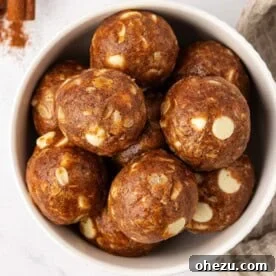 Creamy white chocolate pumpkin spice energy bites, featuring white chocolate drizzle and autumn spices