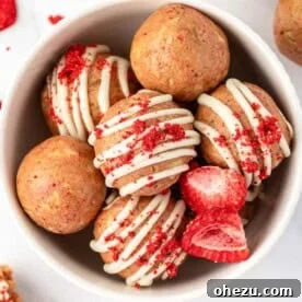 Sweet strawberries and cream energy bites, possibly with a white chocolate drizzle
