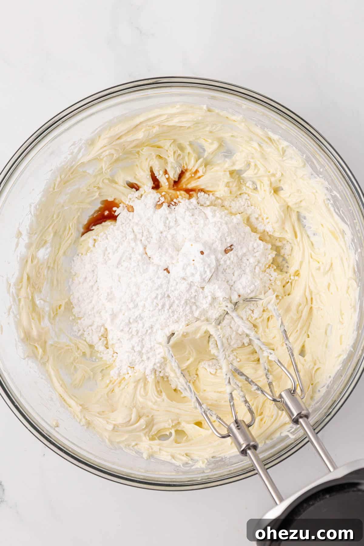 All ingredients for cream cheese frosting combined in a bowl, before beating to perfection