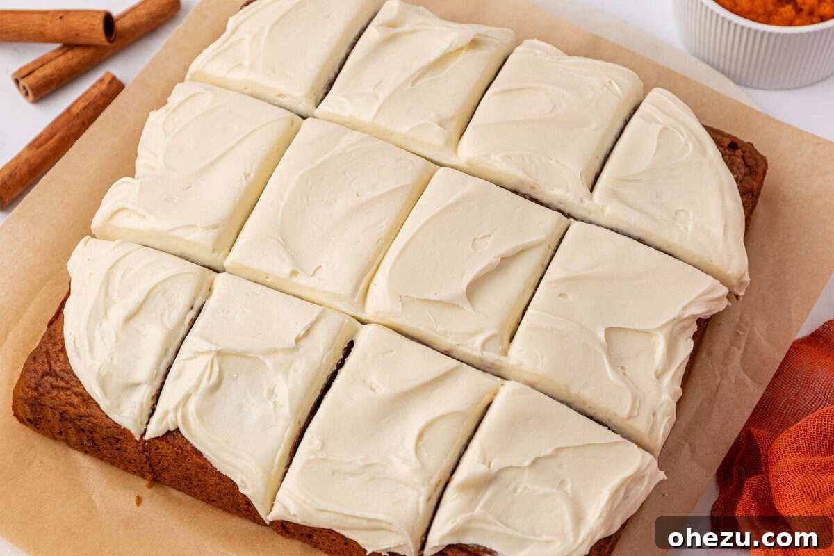 Perfectly cut pumpkin snack cake squares with cream cheese frosting, ready for sharing