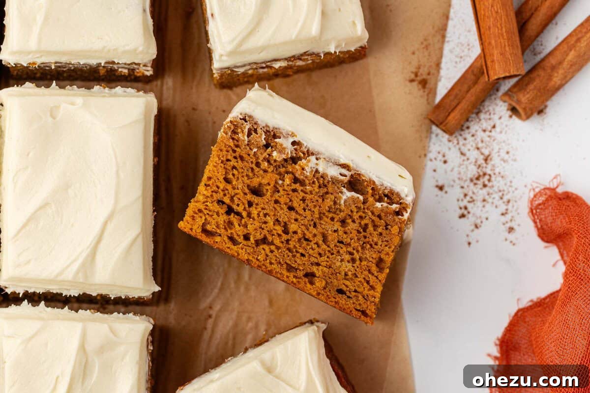 A close-up view of a perfectly baked and frosted pumpkin snack cake, highlighting its moist and tender crumb