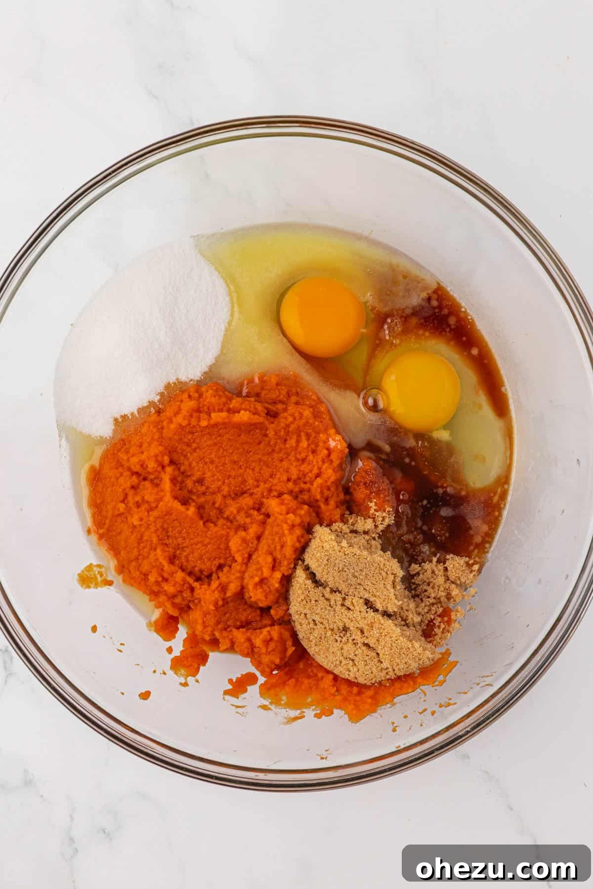 Wet ingredients for pumpkin cake in a mixing bowl, before whisking