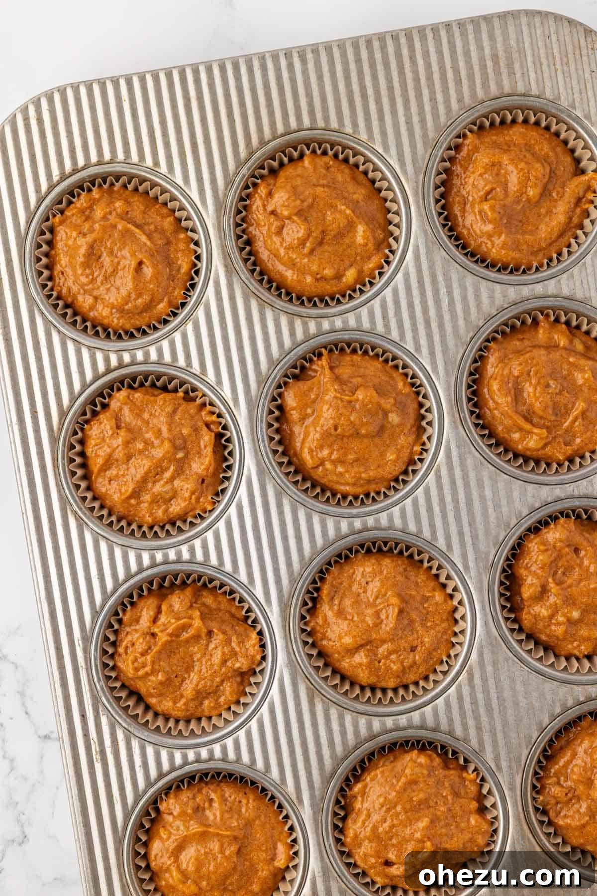 Muffin tin filled ¾ full with pumpkin banana muffin batter