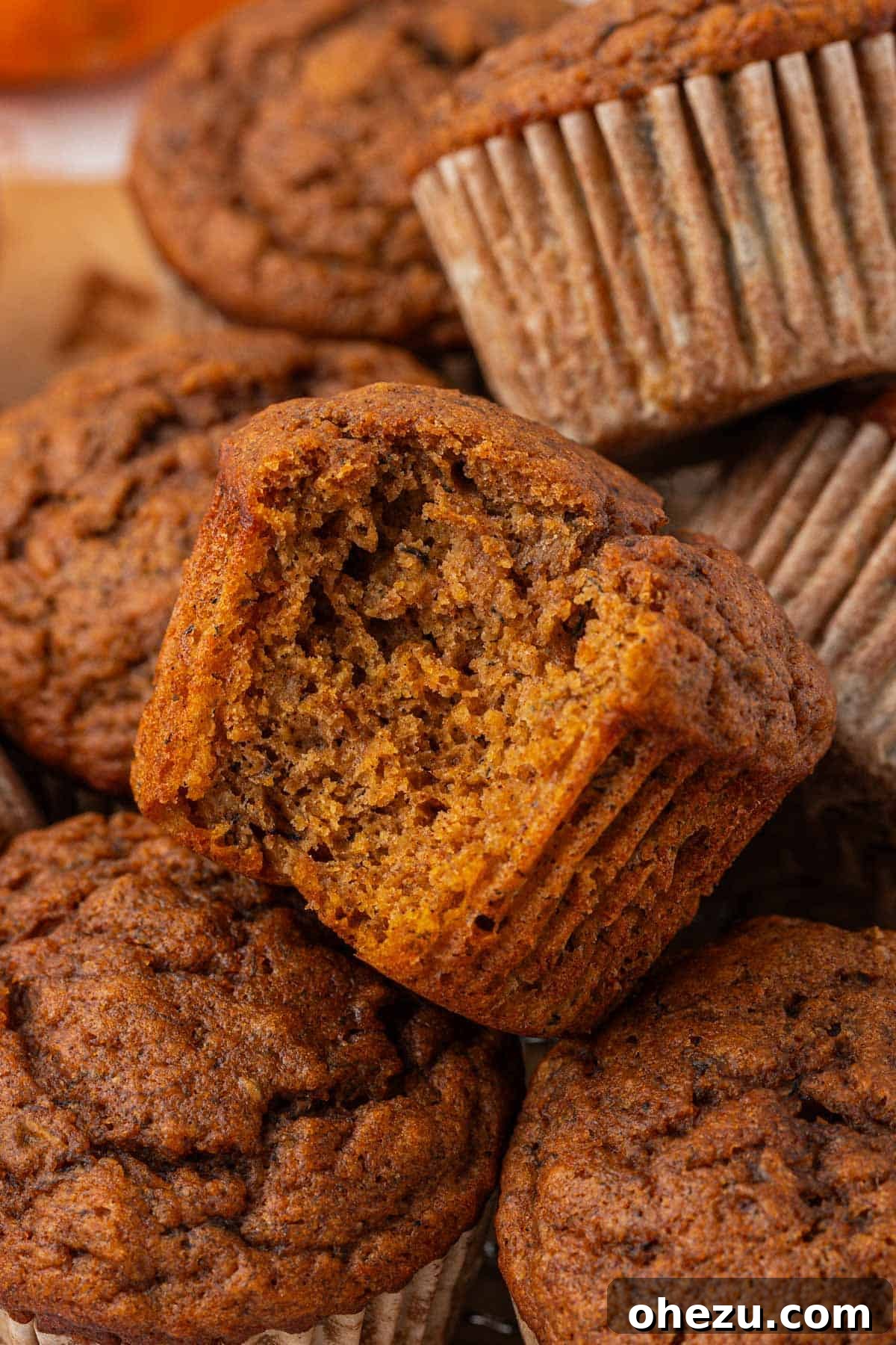 Close-up of a pumpkin banana muffin with a bite taken out, showing its moist interior