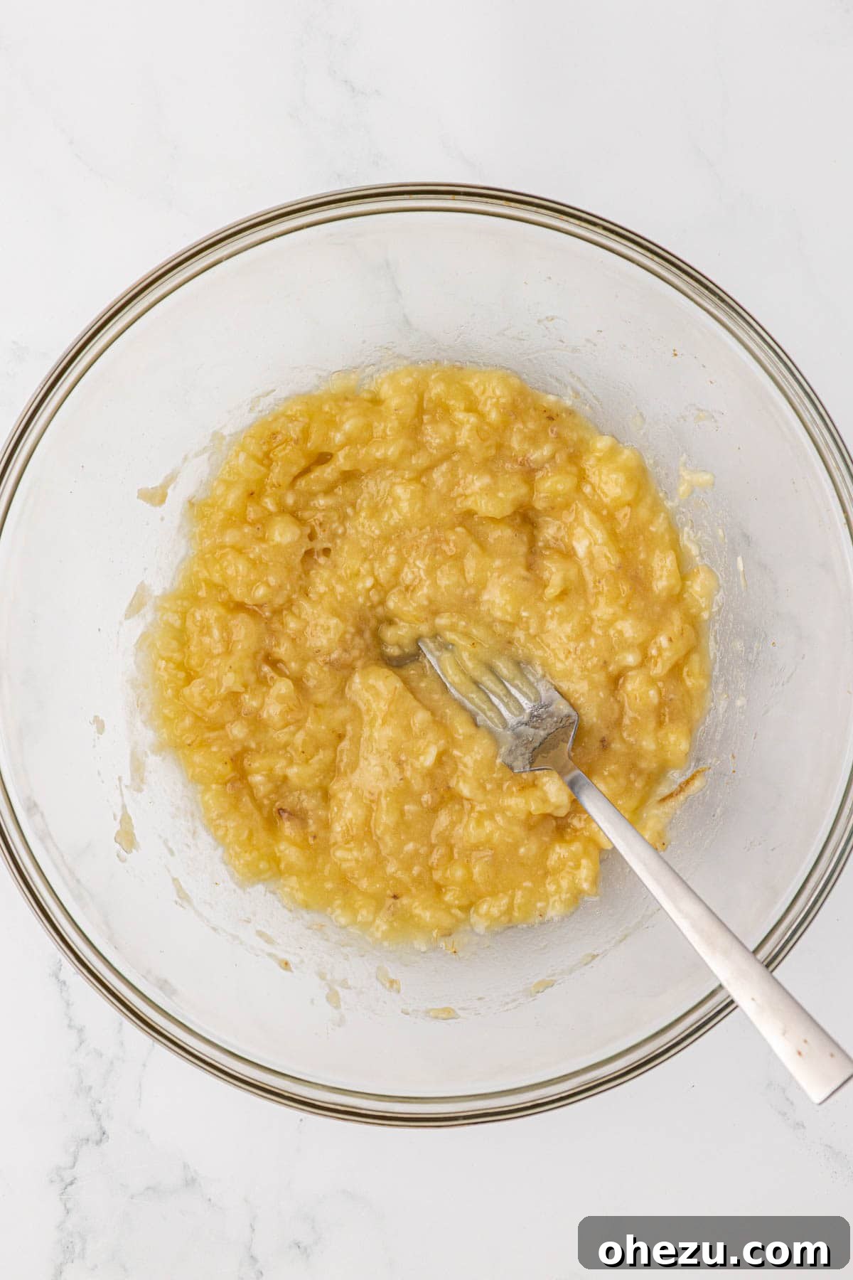 Thoroughly mashed bananas in a bowl with a fork