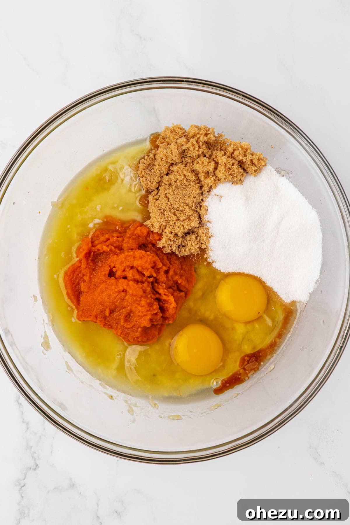 All wet ingredients mixed in a bowl, including pumpkin and banana