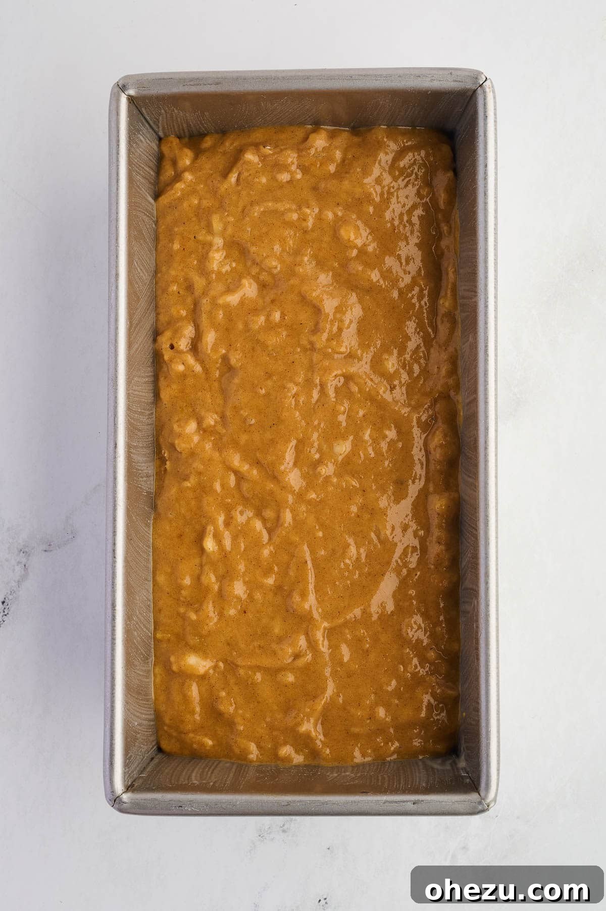 Pumpkin banana bread batter carefully poured and evenly spread into a thoroughly greased loaf pan