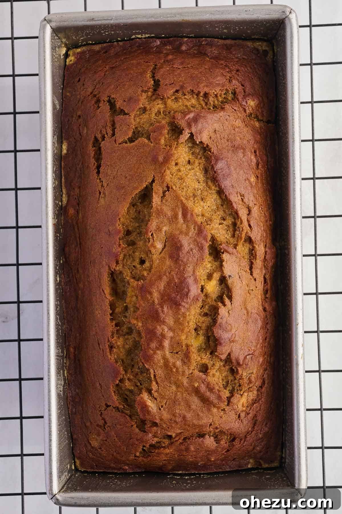 A beautiful, unbaked loaf of pumpkin banana bread with a smooth top, perfectly contained in the loaf pan and ready for the oven