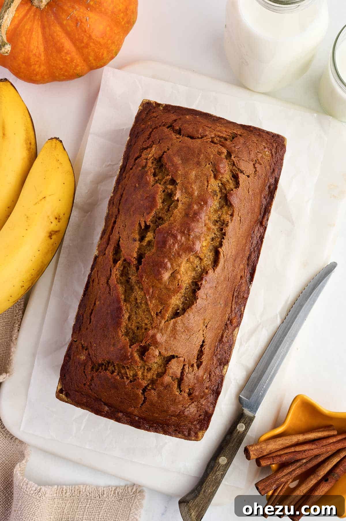 Freshly baked pumpkin banana bread loaf, risen beautifully with a golden-brown crust, fresh out of the oven
