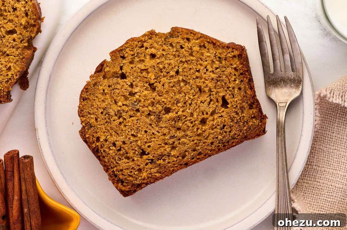 A beautifully baked loaf of pumpkin banana bread presented on a pristine white plate